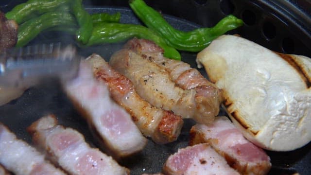 Pork belly sizzling on a grill