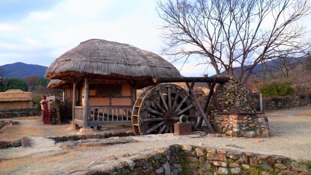 Rustic thatched cottage in the countryside with a watermill
