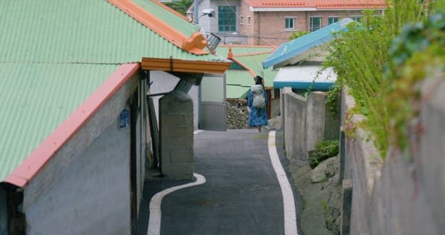 Traveler Walking the Street Between Houses with Colorful Roofs