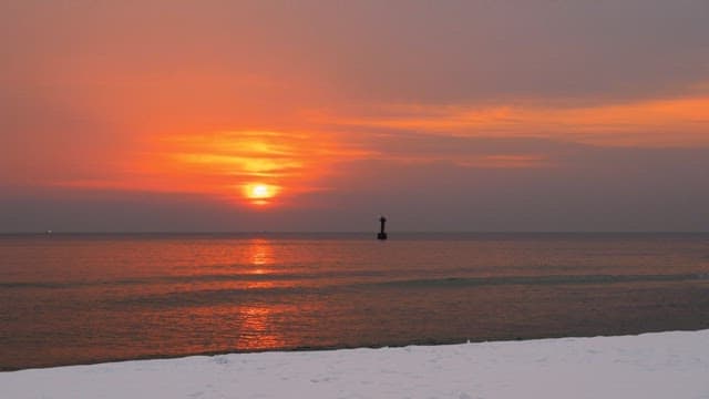 Red sunset coloring the calm and peaceful sea
