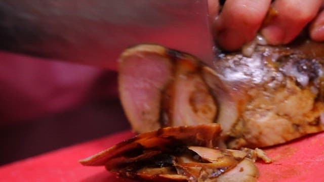 Slicing roasted meat on a cutting board