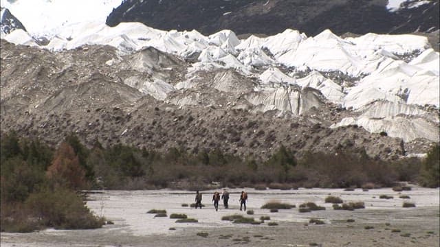 Hikers walking beneath Spantik Gold Peak