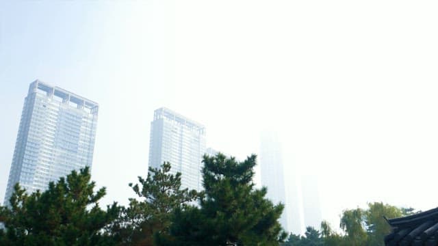 Traditional pavilion by a city park with skyscrapers in the background