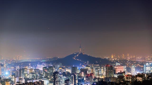 Skyline of a bustling city at night turning to dawn