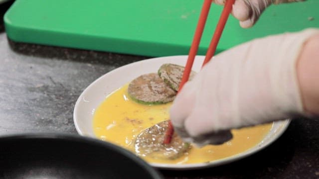 Cooking zucchini pancakes in an oiled frying pan in the kitchen
