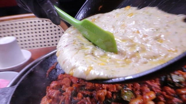 Corn cheese poured over spicy stir-fried chicken