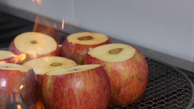Apples being torched on a grill