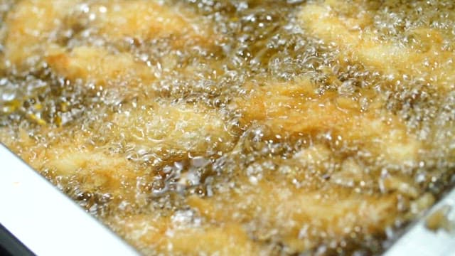 Fried boneless chicken sizzling in hot oil
