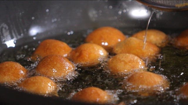 Golden brown doughnuts frying in oil