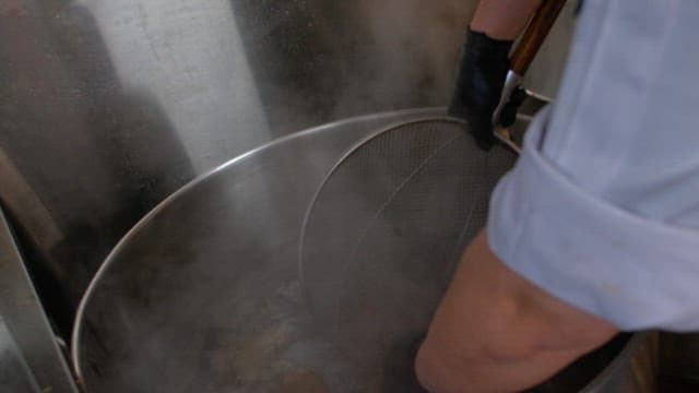 Picking up well-boiled meat and cooling it in cold water