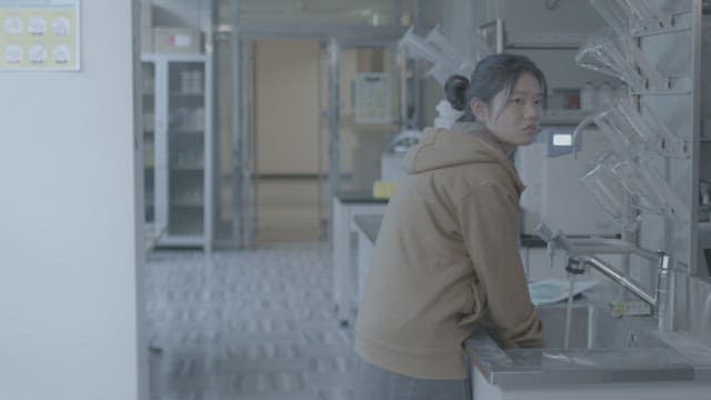 Female student washing hands at the sink in the science lab