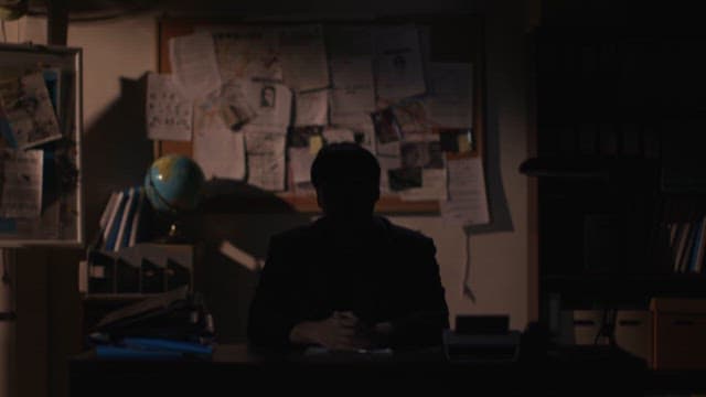 Silhouetted Man Contemplating in a Dark Office