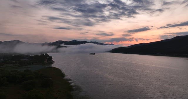 Serene river at sunset with misty mountains