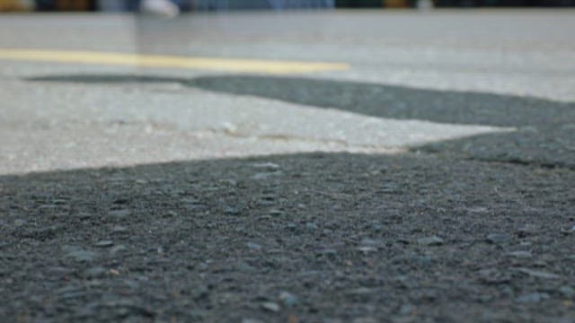 Hand Picking Up a Card Reader that Has Fallen on the Street