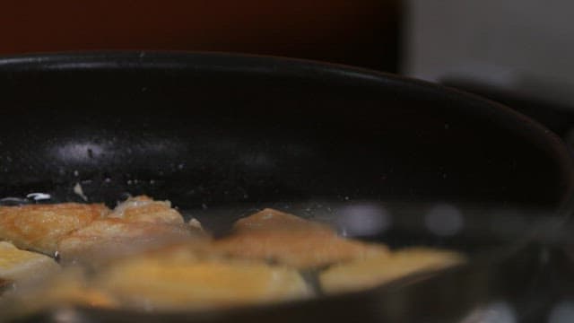 Cooking bamboo shoot pancakes in a frying pan with chopsticks
