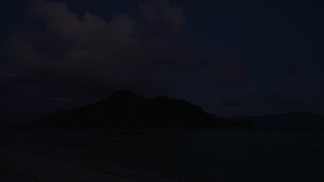 Island surrounded by blue sea under a blue sky