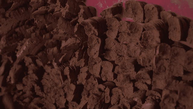 Brown clay being processed by machinery