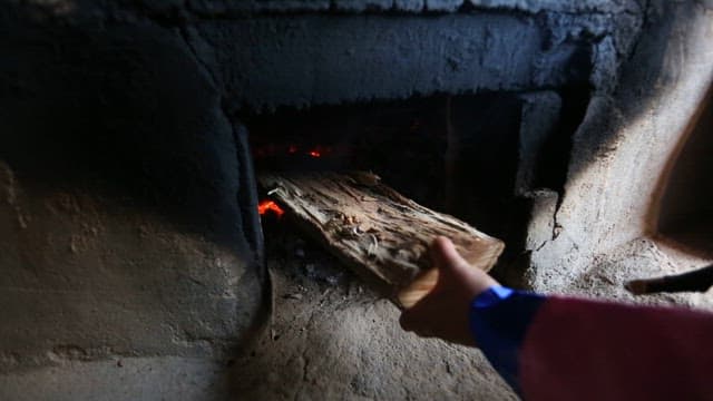 Adding Firewood in a Traditional Korean Brazier to Make a Fire