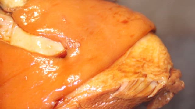 Pouring soy sauce on well-braised pork leg to add shine