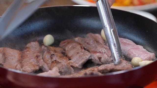 Grilling pork with garlic in a pan