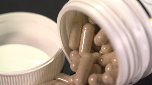 Close-up of Capsules Spilling from a Bottle