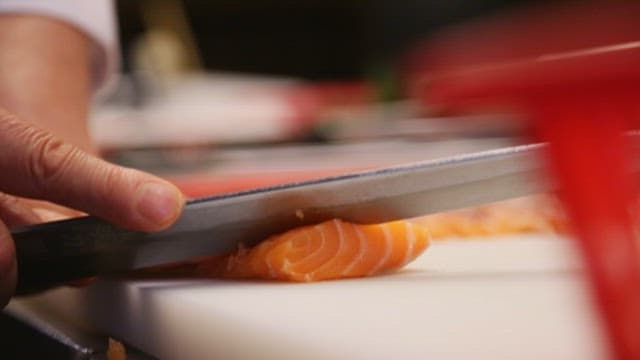 Chef Preparing Salmon Sushi in a Kitchen