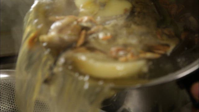Pouring hot broth into a strainer
