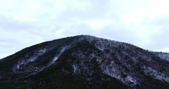 Snow-covered mountains under cloudy skies