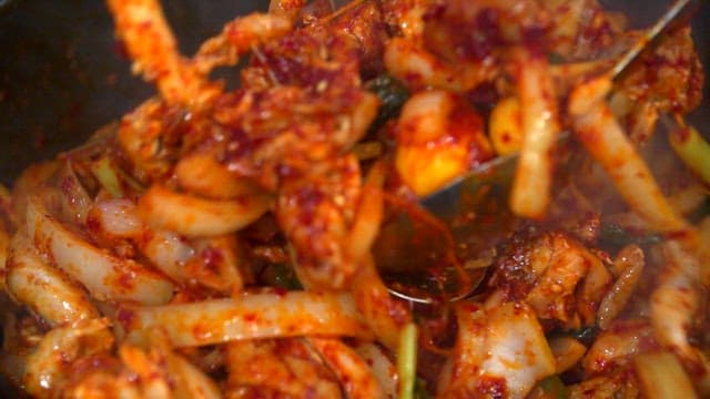 Mixing spicy braised chicken with seasoning