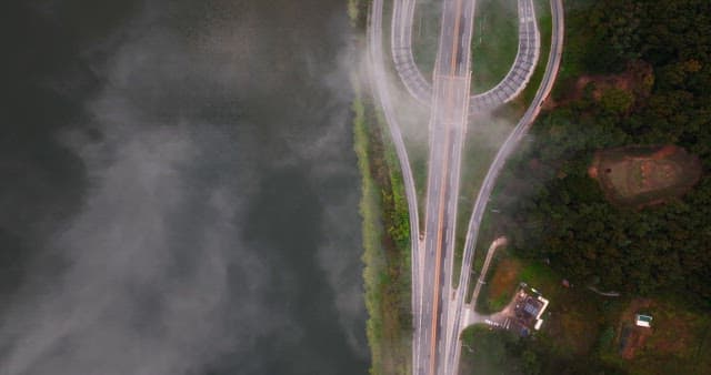 Foggy highway by a river and forest