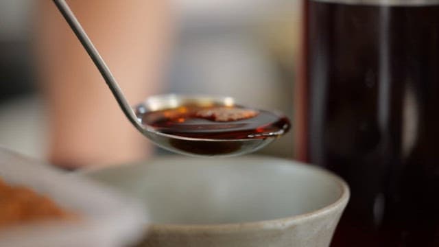 Pouring Soy Sauce into a Bowl with a Ladle