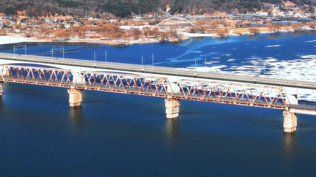 Winter Train Crossing a Bridge Over Frozen River