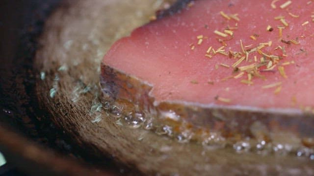 Tuna steaks cooked in hot oil in a frying pan