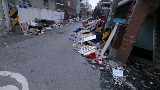 Alley strewn with discarded household items
