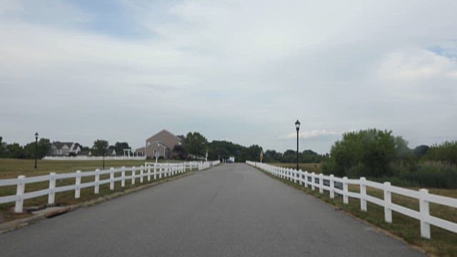 Peaceful Suburban Road Lined with White Fences