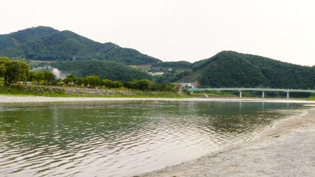 Calm riverside with distant green hills