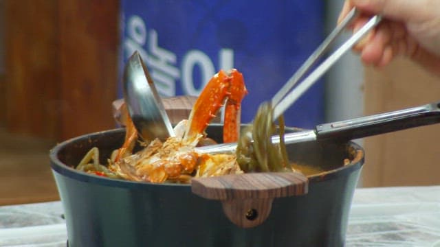 Delicious crab soup with sweet potato stem being scooped out and placed in a bowl