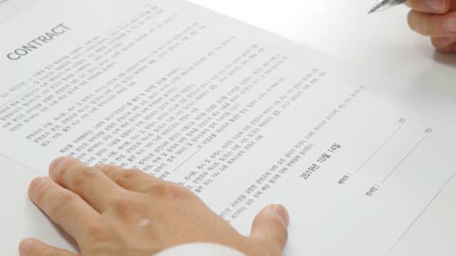 Signing a contract with a pen on a desk