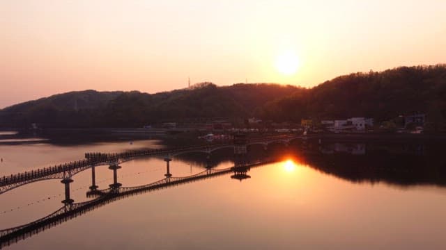 Sunset over a tranquil river and bridge