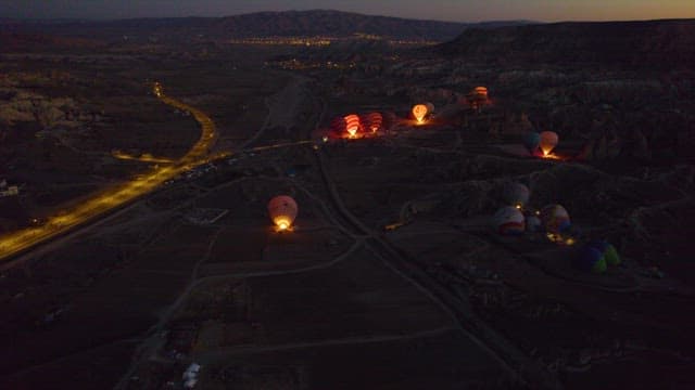 Hot Air Balloons Over Rugged Terrain at Dusk