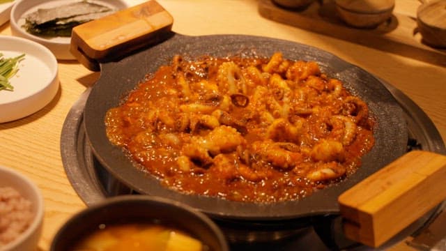 Sizzling Spicy Octopus Dish Garnished with Cheese