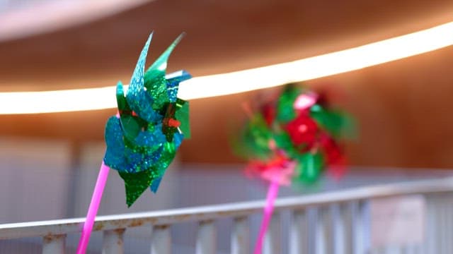 Colorful pinwheels spinning on a metal fence