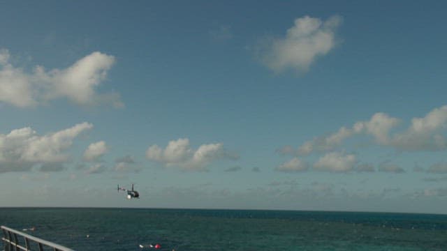 Helicopter flying over the ocean