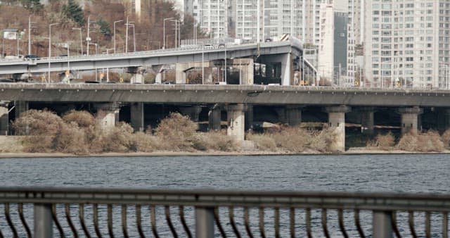 Bridge Over River with City Buildings in Background