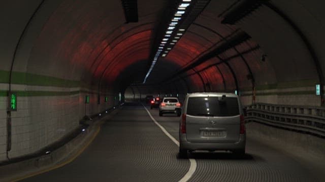 Vehicles Moving Through an Illuminated Tunnel