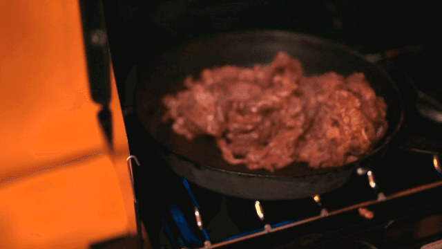 Cooking beef bulgogi stir-fry in a frying pan on a stove