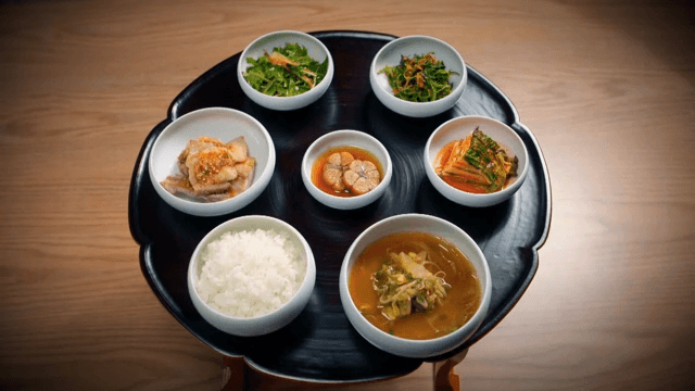Traditional Korean meal including kimchi, soup, and rice served on a wooden tray
