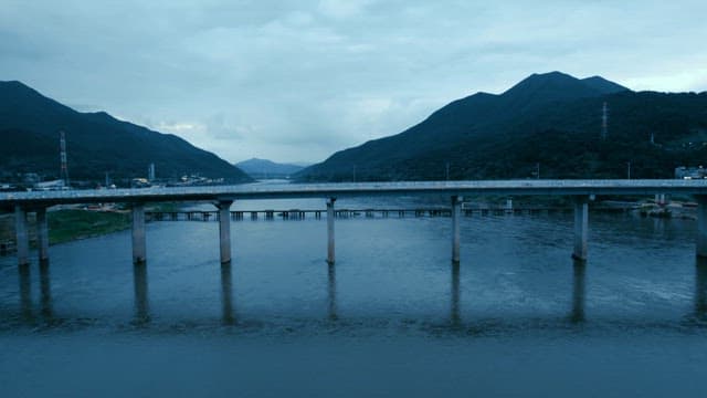 Bridge with cars passing over a river with city skyline