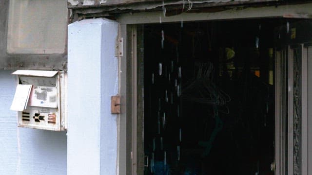 Rain falling on an old mailbox beside the door