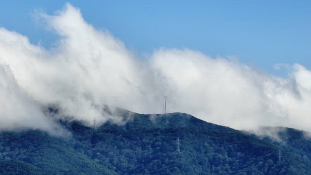 Wind turbine on a mountain with clouds